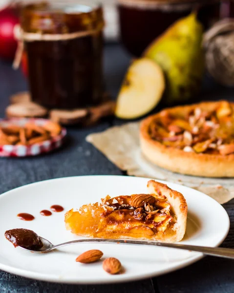 Stück Apfelkuchen auf einem runden Teller, Löffel Karamell — Stockfoto