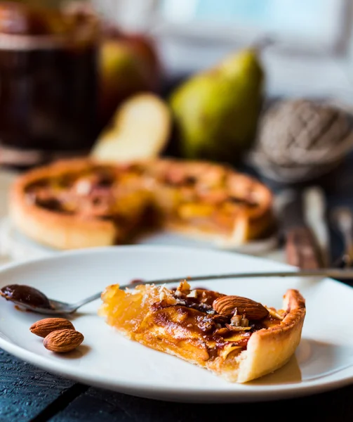 Tarte aux pommes sur une assiette blanche, cuillère caramel — Photo