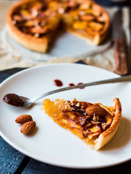 Stück Apfelkuchen auf weißem Teller, Löffel Karamell — Stockfoto