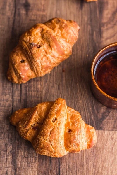 Croissant con chocolate en una tabla de madera, taza de café — Foto de Stock