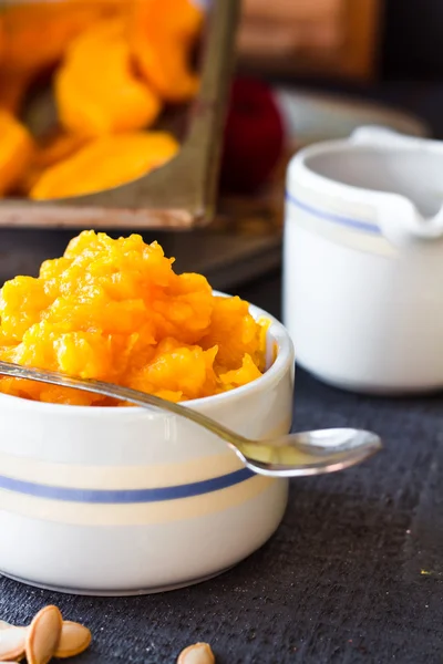 Pumpkin puree in a ceramic bowl with spoon, healthy dessert — Stock Photo, Image