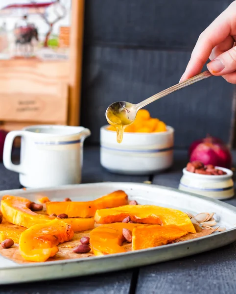 Pour honey roasted pumpkin slices with cinnamon on parchment — Stock Photo, Image