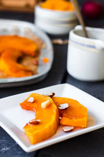 Baked pumpkin with honey and nuts on a white plate — Stock Photo, Image