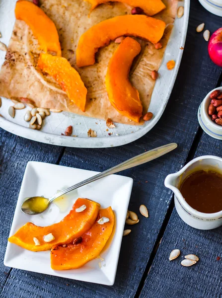 Baked pumpkin slices with cinnamon and nuts, spoon with honey — Stock Photo, Image