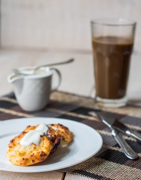 Panquecas de queijo cottage com creme de leite e café, café da manhã — Fotografia de Stock