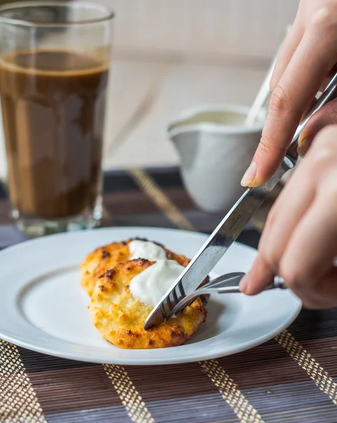 Äta Kvarkpaj pannkakor med gräddfil till frukost, händer — Stockfoto