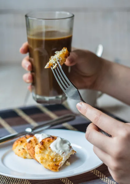 Їж сирні млинці зі сметаною на сніданок, руки — стокове фото