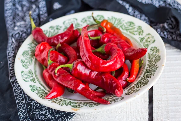 Fresh chili pepper in a plate on a board — Stock Photo, Image