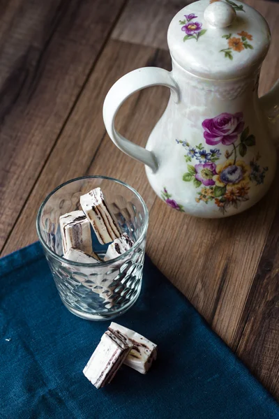 Nougat candy in a glass and tea, blue napkin — Stock Photo, Image