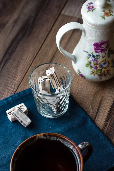 Nougatbonbons im Glas und Tee, blaue Serviette — Stockfoto
