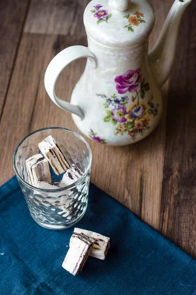 Nougat candy in a glass and tea, blue napkin — Stock Photo, Image