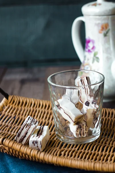 Bonbons im Glas auf einem Holzkorb und Tee — Stockfoto