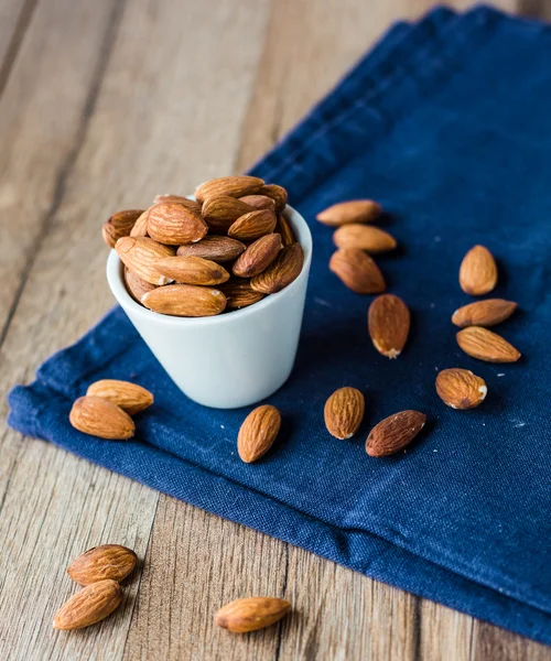 Almond nuts on blue cloth — Stock Photo, Image