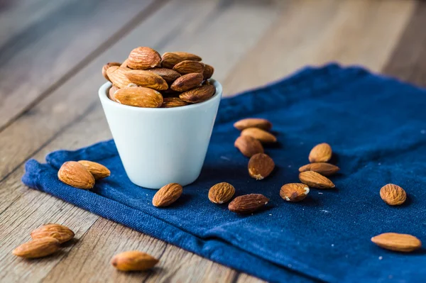 Almond nuts on blue cloth — Stock Photo, Image