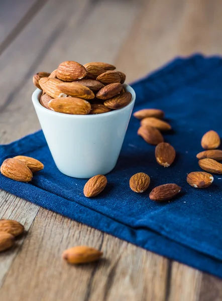 Almond nuts on blue cloth — Stock Photo, Image