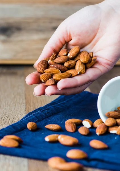 A handful of almonds in his hand — Stock Photo, Image