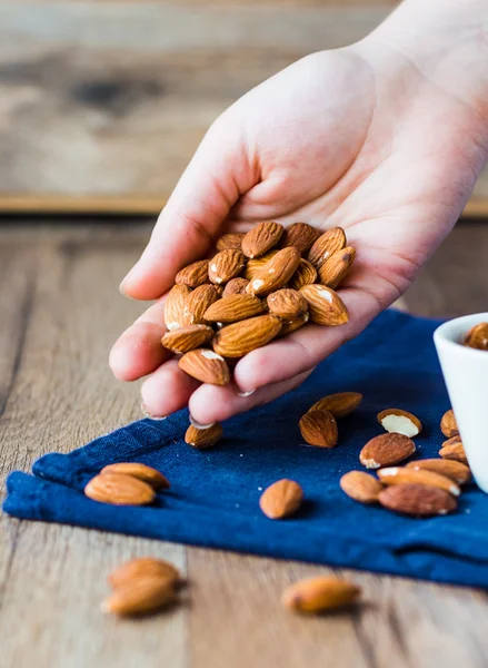 A handful of almonds in his hand — Stock Photo, Image