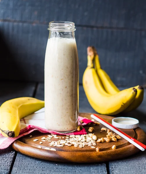 Banana smoothie with oat flakes and milk in the bottle