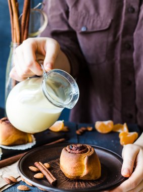 Cinnabon tarçın krem sos dökmek için el rulo