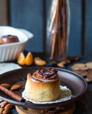 Cinnabon tarçın rulo, badem ve mandalina karanlık bir plaka üzerinde