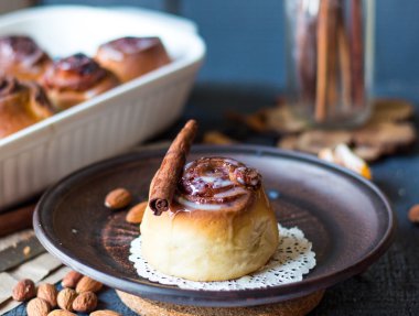 Cinnabon tarçın rulo, badem ve mandalina karanlık bir plaka üzerinde
