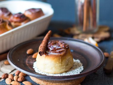 Cinnabon tarçın rulo, badem ve mandalina karanlık bir plaka üzerinde