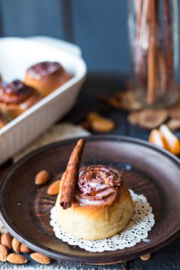 Cinnabon tarçın rulo, badem ve mandalina karanlık bir plaka üzerinde