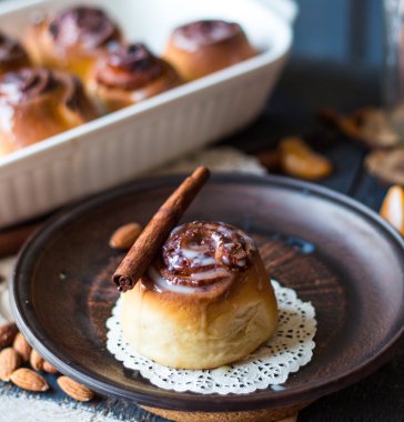 Cinnabon tarçın rulo, badem ve mandalina karanlık bir plaka üzerinde