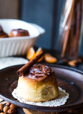 Cinnabon tarçın rulo, badem ve mandalina karanlık bir plaka üzerinde