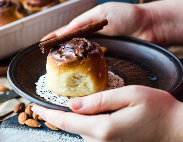 Hold in your hand with the Cinnabon cinnamon rolls and cream sau — Stock Photo, Image
