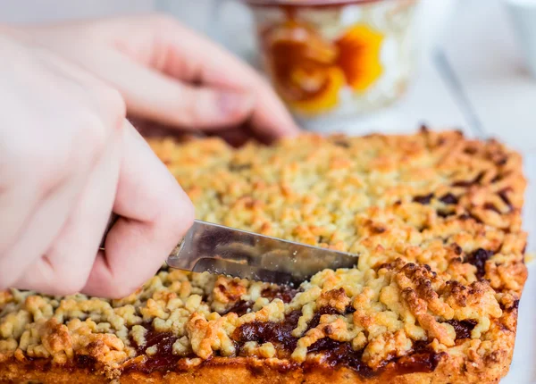 Cut sweet tart pastry with apple jam, hands — Stock Photo, Image