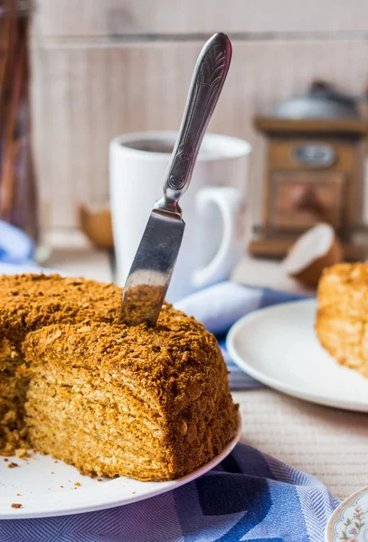 Couper le gâteau de la pâtisserie avec du miel et de la crème sure — Photo