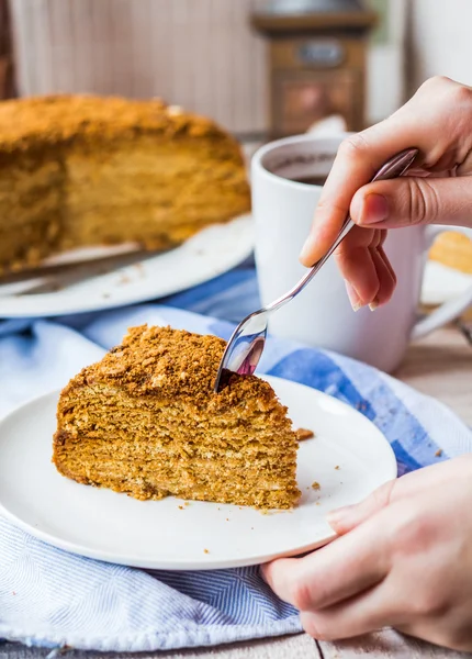 Їдять медовий торт зі сметаною та горіхами, рука — стокове фото