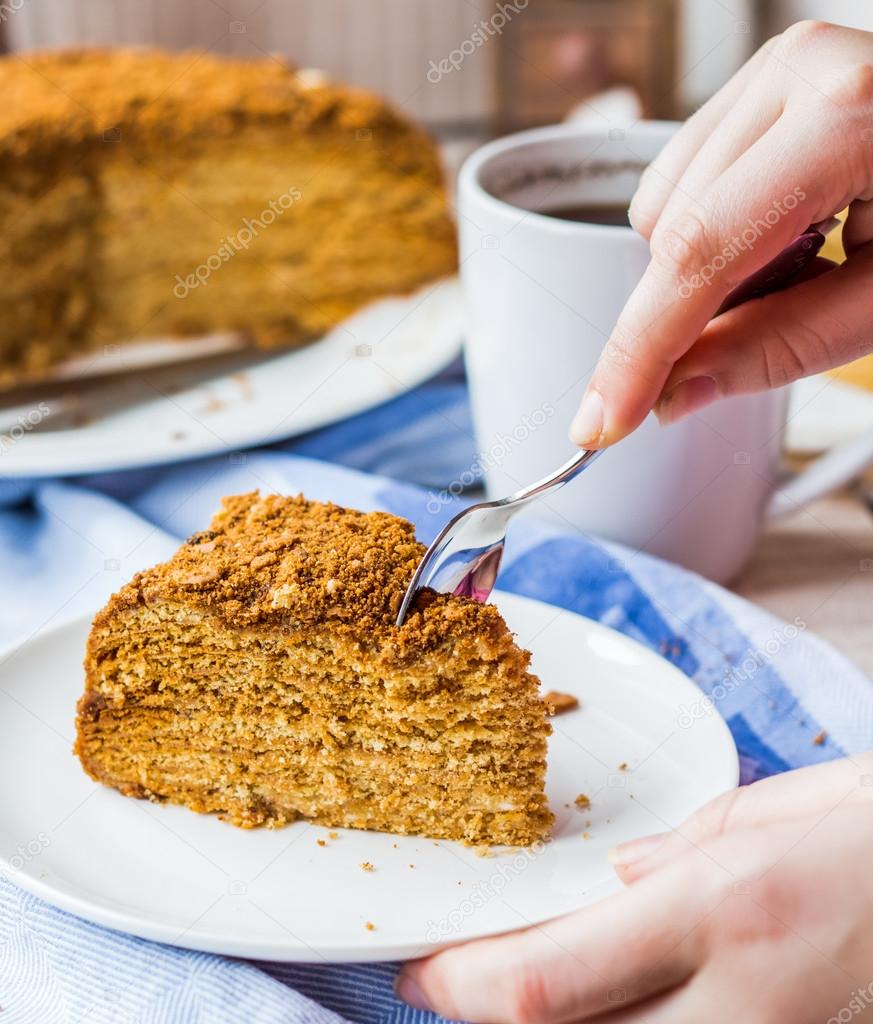 eating honey cake with sour cream and nuts, hand