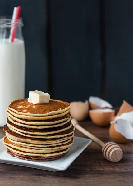 Pfannkuchen mit Butter und Honig, eine Flasche Milch, Dessert — Stockfoto