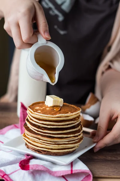 Haufen Pfannkuchen mit Butter, gießen Honig, Hand — Stockfoto