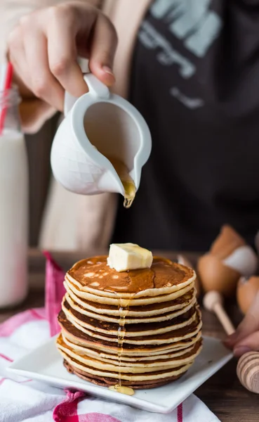 Haufen Pfannkuchen mit Butter, gießen Honig, Hand — Stockfoto