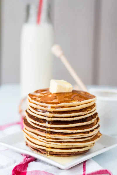 Pannkaka med smör och honung, en flaska mjölk, dessert — Stockfoto