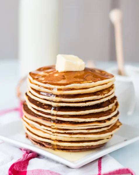 Pancake con burro e miele, una bottiglia di latte, dessert — Foto Stock