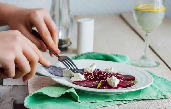 Comer ensalada de remolacha con queso de cabra, ajo y sésamo, manos —  Fotos de Stock