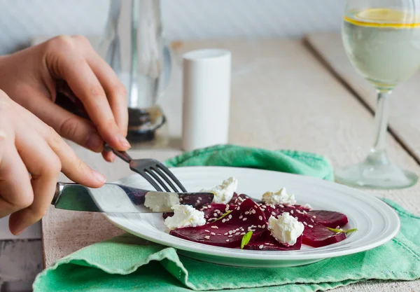 Comer ensalada de remolacha con queso de cabra, ajo y sésamo, manos —  Fotos de Stock