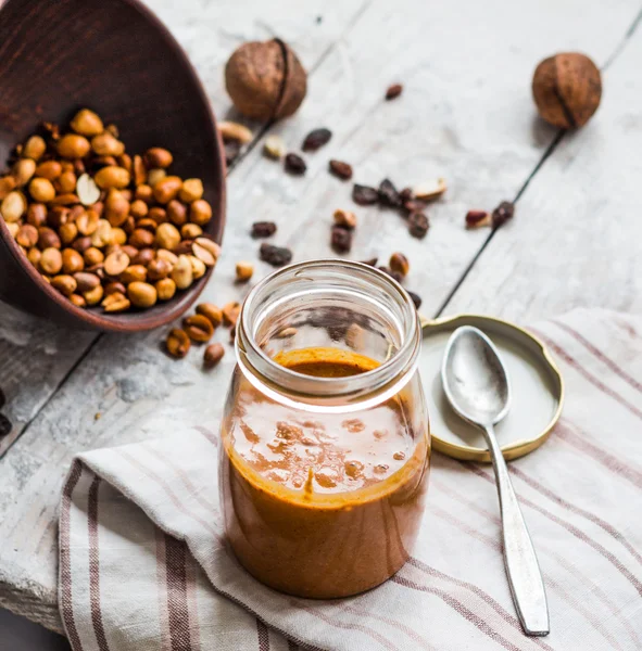 Beurre d'arachide fait maison, et noix sur un fond clair — Photo