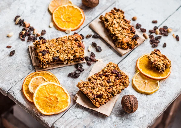 Granola bárok, citrusfélék, a mogyoróvajat és a szárított gyümölcsök, egészséges táplálkozás — Stock Fotó