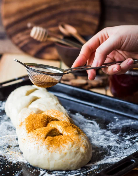Масло сире тісто посипане корицею, процес сита, рука — стокове фото