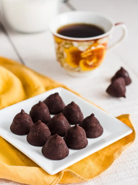 Trufla czekoladki z filiżanką kawy i krem — Zdjęcie stockowe