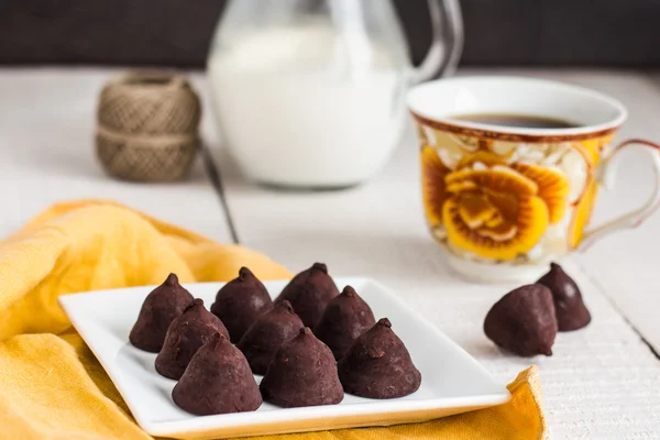 Chocolates de trufa con una taza de café y crema —  Fotos de Stock