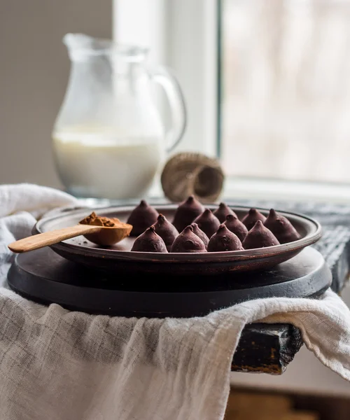 Snoep chocolade truffels op een plaat van donkere en room in een kruik, — Stockfoto