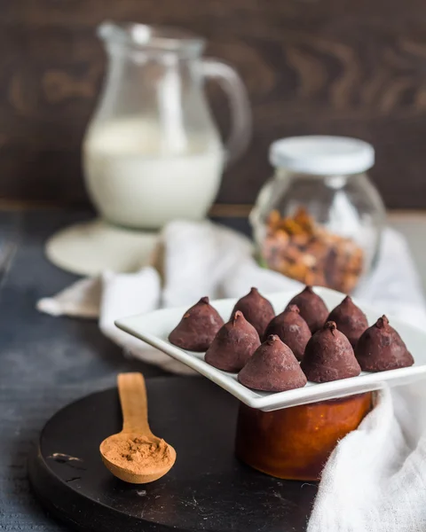 Godis choklad tryffel, grädde kannan och en kopp kaffe — Stockfoto