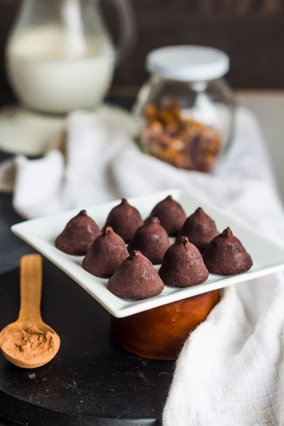 Trufas de chocolate doce, jarro de creme e uma xícara de café — Fotografia de Stock