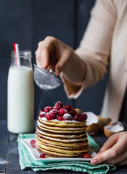 Pancake with cranberries and raspberries sprinkled with powdered